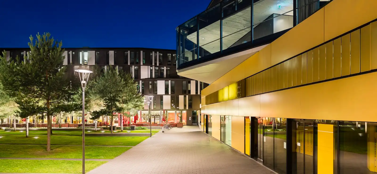 Modern university campus in Aachen at night, symbolizing digital learning and custom university apps by Sunbird Images